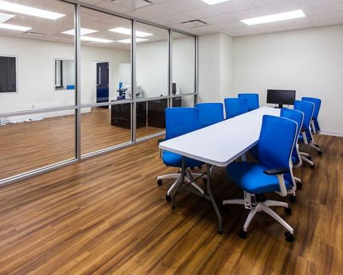 MAAS航空涂装设施内的会议室. 大房间，中间有会议桌和蓝色椅子.